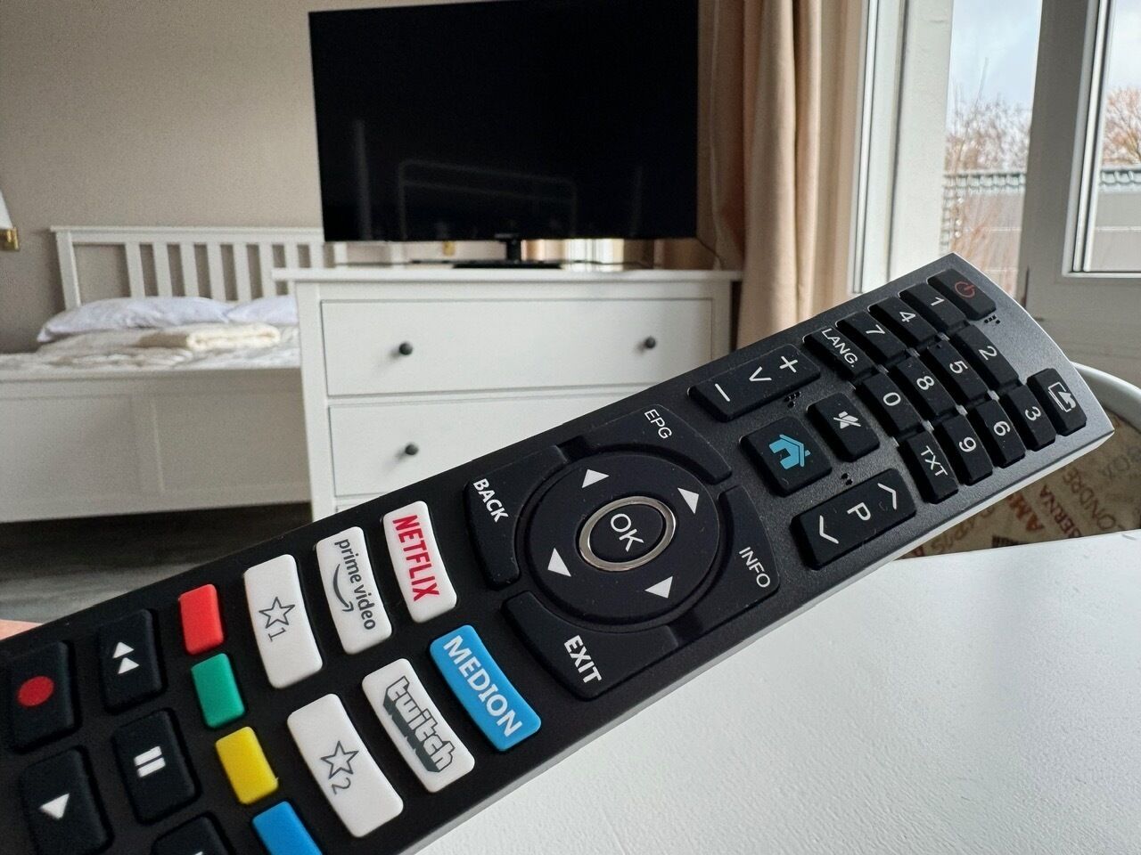 A remote control with labeled buttons for Netflix, Prime Video, and Twitch.