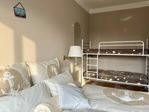 A bedroom with a bunk bed, a bedside table with a lamp, and a wall-mounted sign. - Pension Ostsee-Strand (Boergerende-Rethwisch)