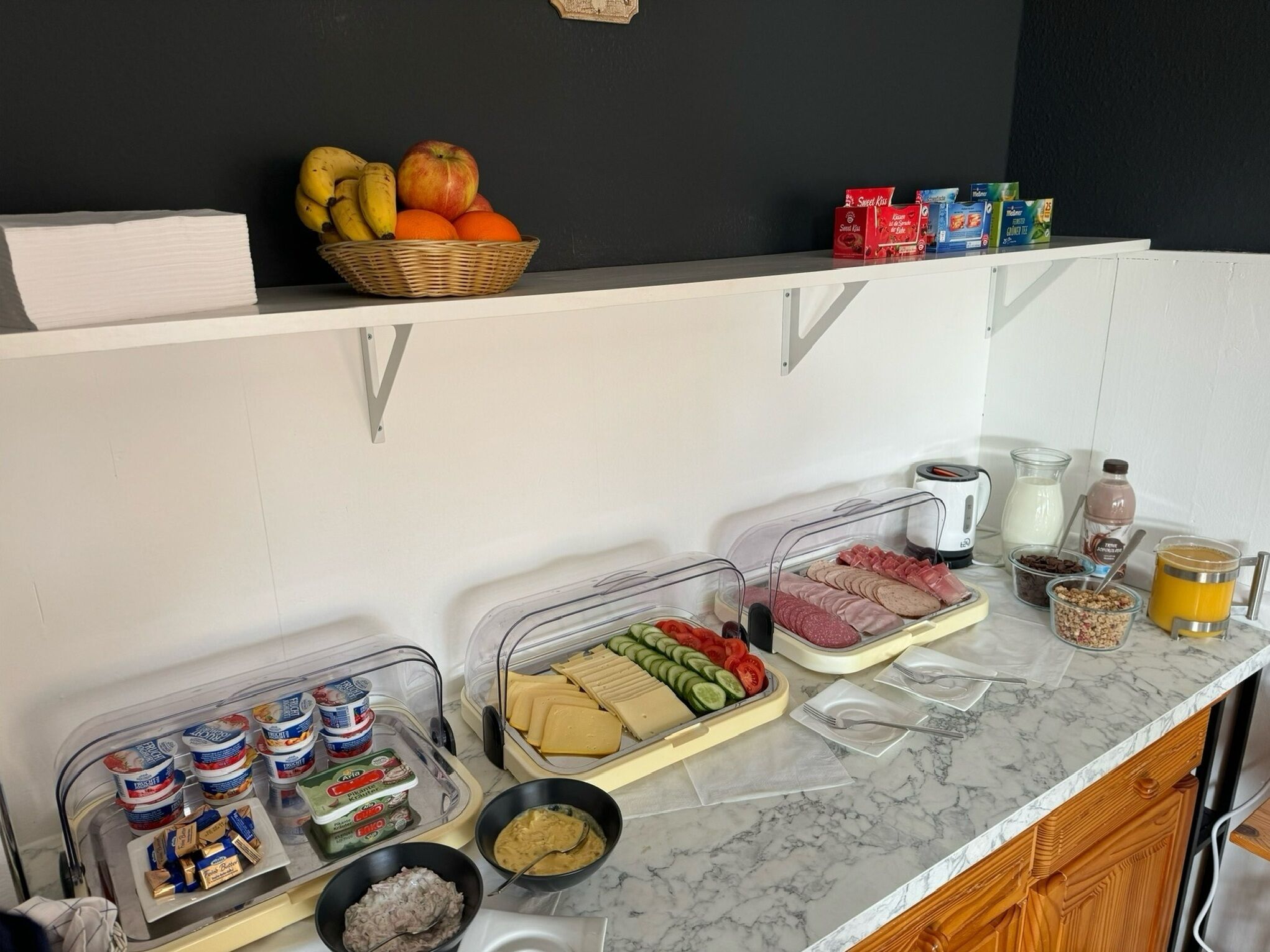 A breakfast buffet setup with various food items and condiments.