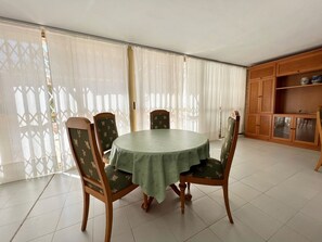 A dining area with a round table, four chairs, and a wooden cabinet. - Alq 266 Etxezuri (Calpe / Calp)