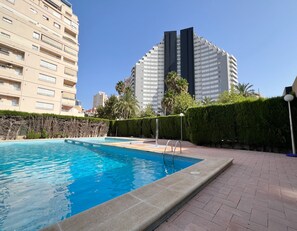 A swimming pool with a tiled edge, a paved walkway, and a hedge. - Alq 266 Etxezuri (Calpe / Calp)