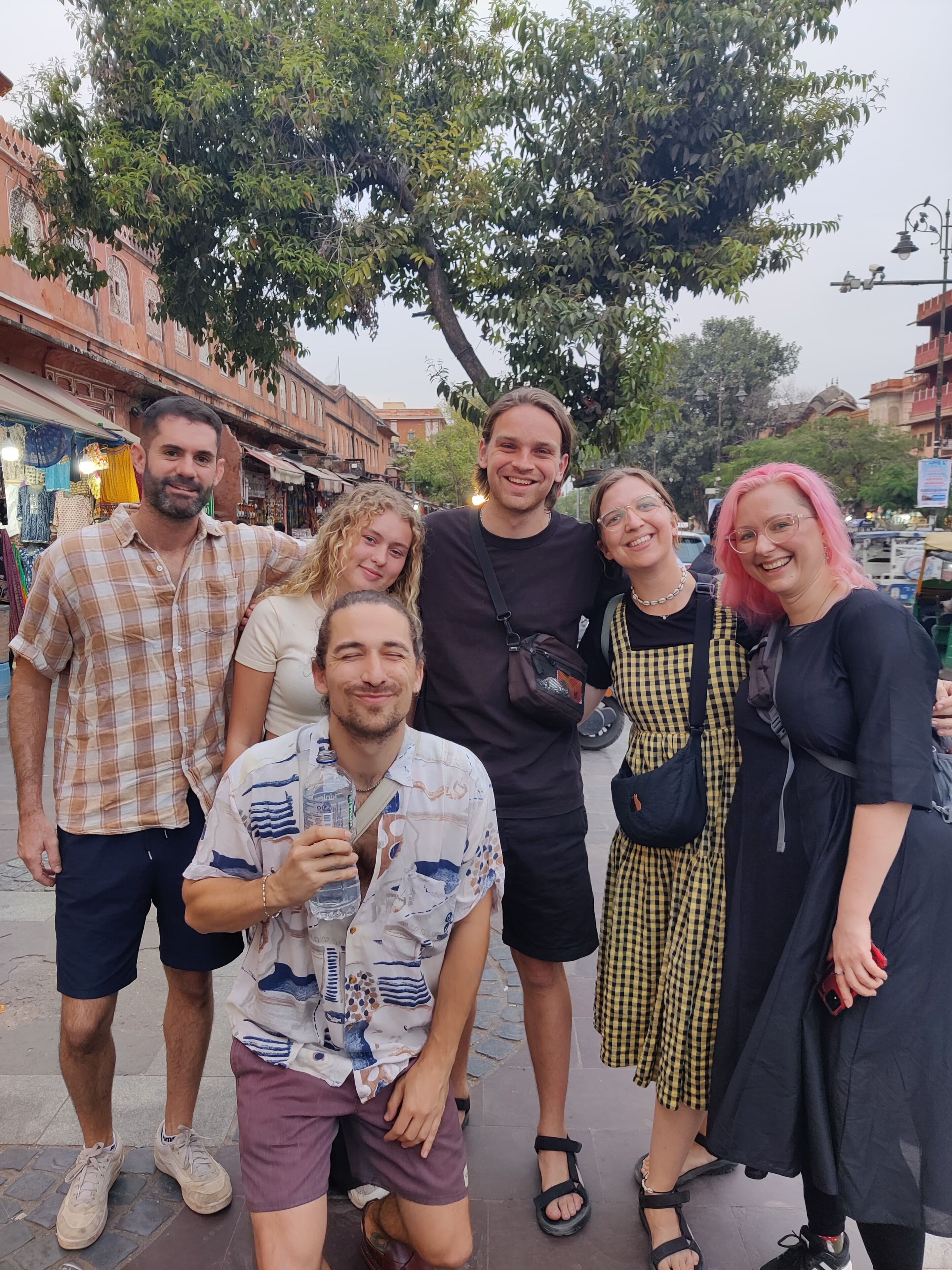 Un groupe de personnes posant devant un bâtiment à l’architecture traditionnelle.