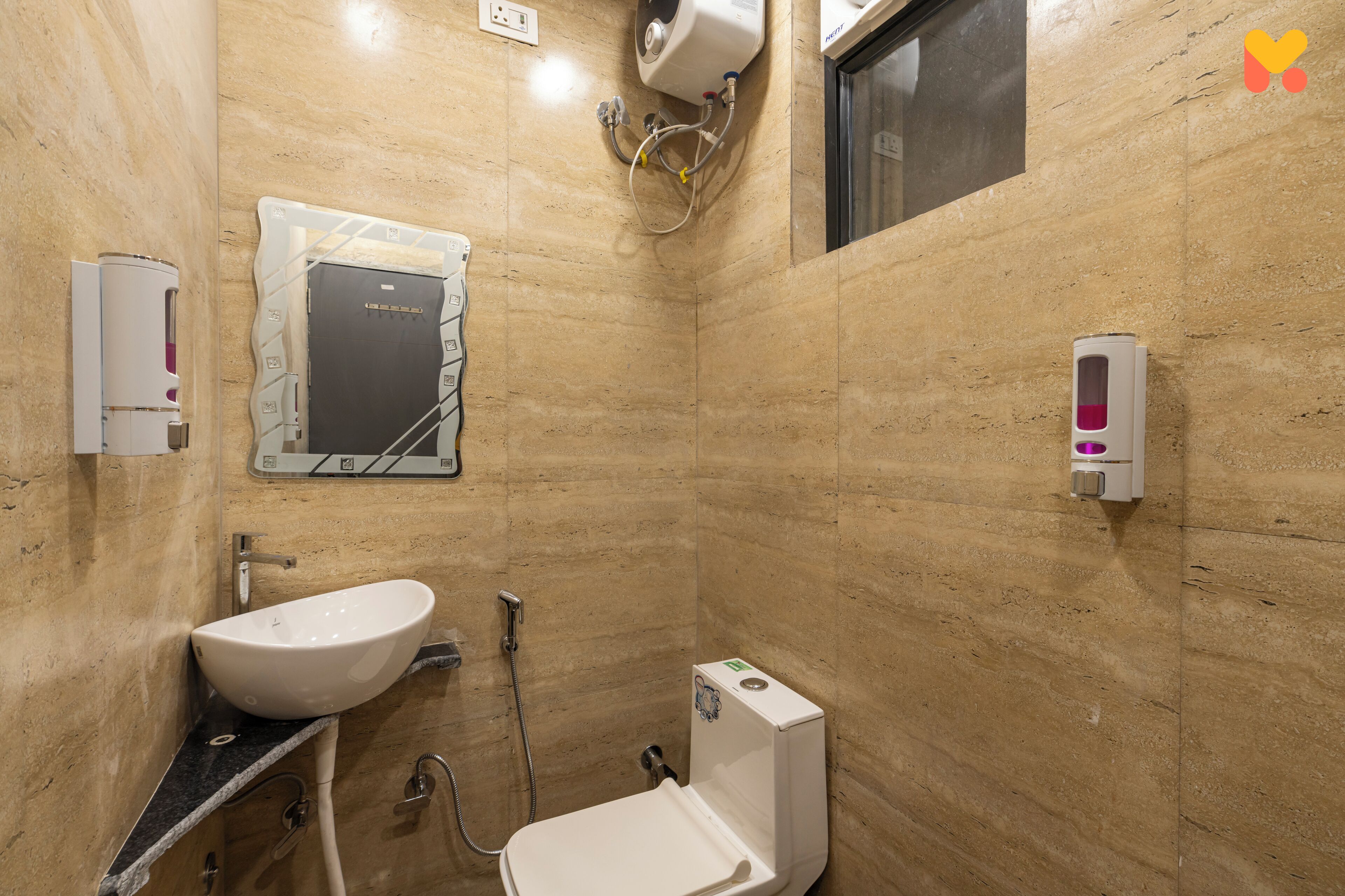 Un baño pequeño y moderno con lavabo, inodoro y secamanos.