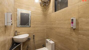 Un baño pequeño y moderno con lavabo, inodoro y secamanos.