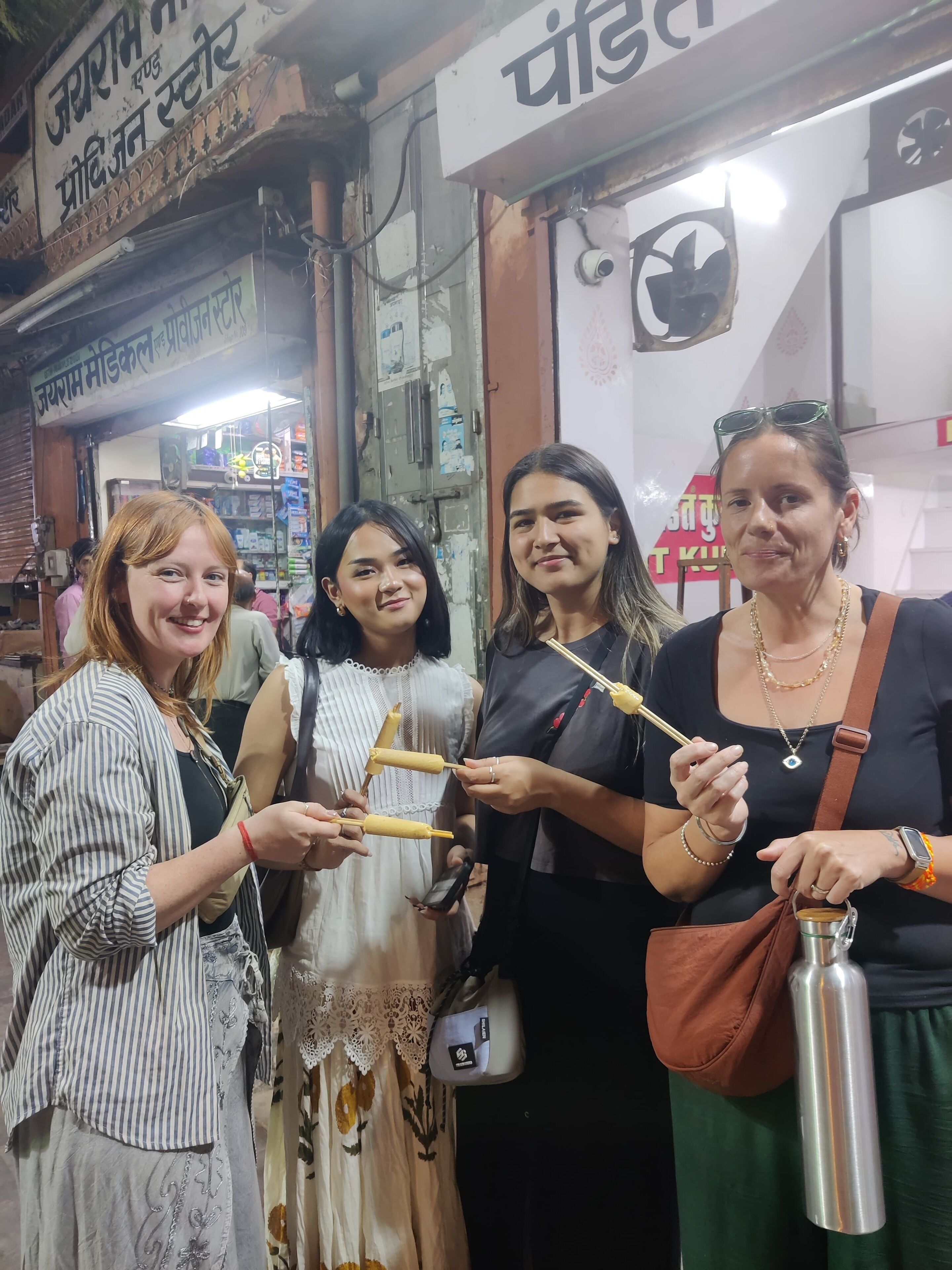 Un grupo de personas de pie frente a una tienda con un letrero en un idioma diferente al inglés.