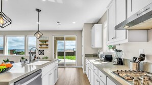 A modern kitchen with a large island, stainless steel appliances, and a view to the outdoors. - 5BD Modern Home: Pool/Ping-Pong/Arcade - Wine City (Fairfield)