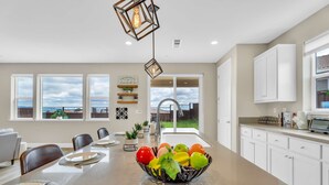 A modern kitchen with a central island, white cabinets, and a view of the outdoors. - 5BD Modern Home: Pool/Ping-Pong/Arcade - Wine City (Fairfield)
