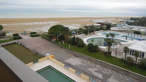 A pool area with a view of the beach and ocean.