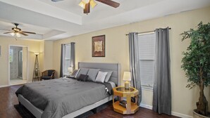 A bedroom with a large bed, two ceiling fans, a nightstand, a potted plant, and a window with curtains. - ~Bamboo Oasis Relaxing Hot Tub Family Time~ Get to Anywhere in SA in 20 mins! (San Antonio)