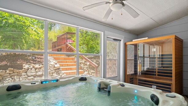 A hot tub with a view of a wooden deck and stone wall. - ~Bamboo Oasis Relaxing Hot Tub Family Time~ Get to Anywhere in SA in 20 mins! (San Antonio)