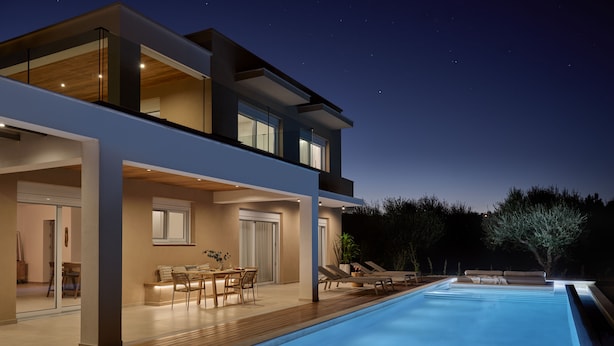 Ein modernes, zweistöckiges Haus mit Schwimmbad, Außenbereich und einer gut beleuchteten Terrasse.