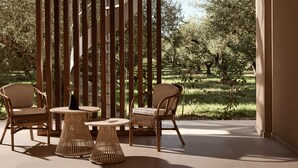 Ein Zimmer mit Blick auf einen Garten, mit Korbmöbeln und einer Holzwand.