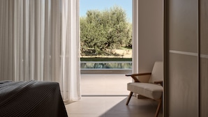 Ein modernes Zimmer mit einer großen Schiebeglasdoor zum Außenbereich mit Pool und Bäumen.