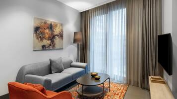 Ein modernes Wohnzimmer mit einer Couch, einem Couchtisch und einem orangefarbenen Sessel.