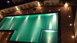 A swimming pool with multiple light fixtures and a tiled border. - Samsara (Boossa)