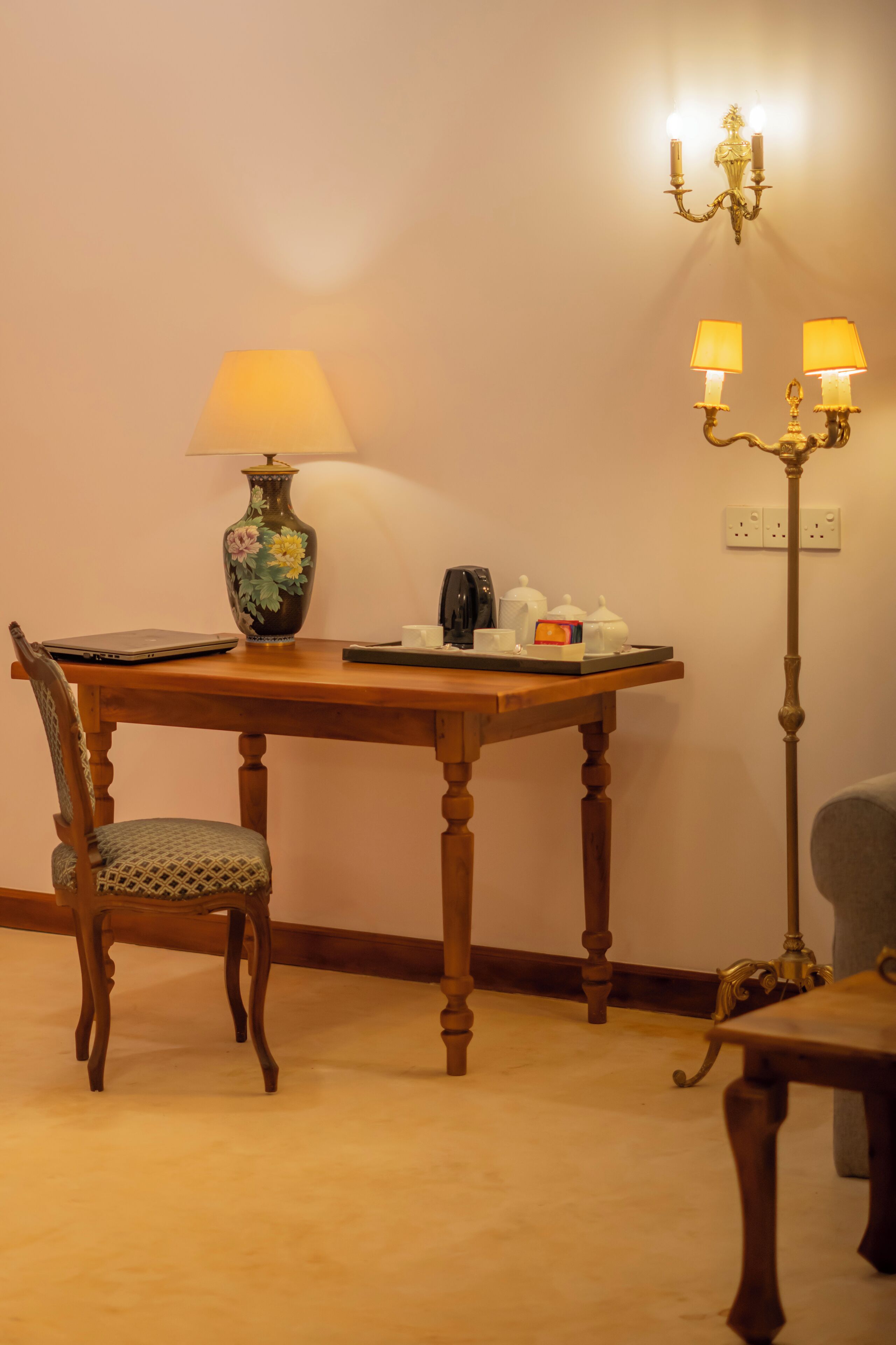 Une table à manger en bois, une lampe, une chaise et un lampadaire.
