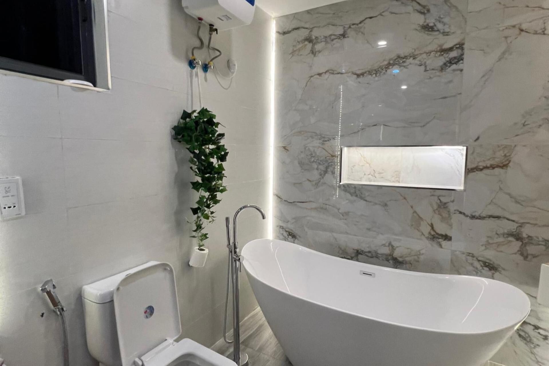 Une salle de bain moderne avec une baignoire sur pieds, des toilettes et une douche.