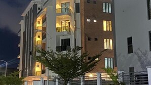 A multi-story building with balconies, large windows, and a modern architectural design.