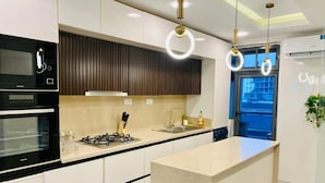A modern kitchen with white cabinets, a built-in oven, a gas stove, and pendant lighting.