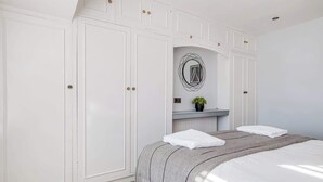 Une chambre à coucher avec un grand lit, une armoire et un miroir au design circulaire.