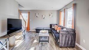A modern living room with a flat-screen TV, a sectional sofa, and a wooden coffee table.