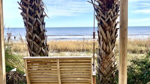 A wooden bench under a wooden structure with a view of the ocean. - Oceanfront Condo, Balcony, Pools, Beach Access, Walk to Restaurants & Boardwalk  (Myrtle Beach)