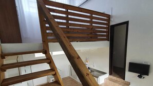 Una escala de fusta amb barana que condueix a una plataforma.