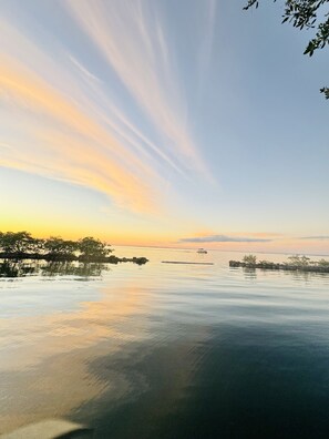 A calm body of water with a distant shoreline, clear sky, and a boat in the distance. - Snowbird specials!! Book now. Minimum stay 28 days. (Key Largo)
