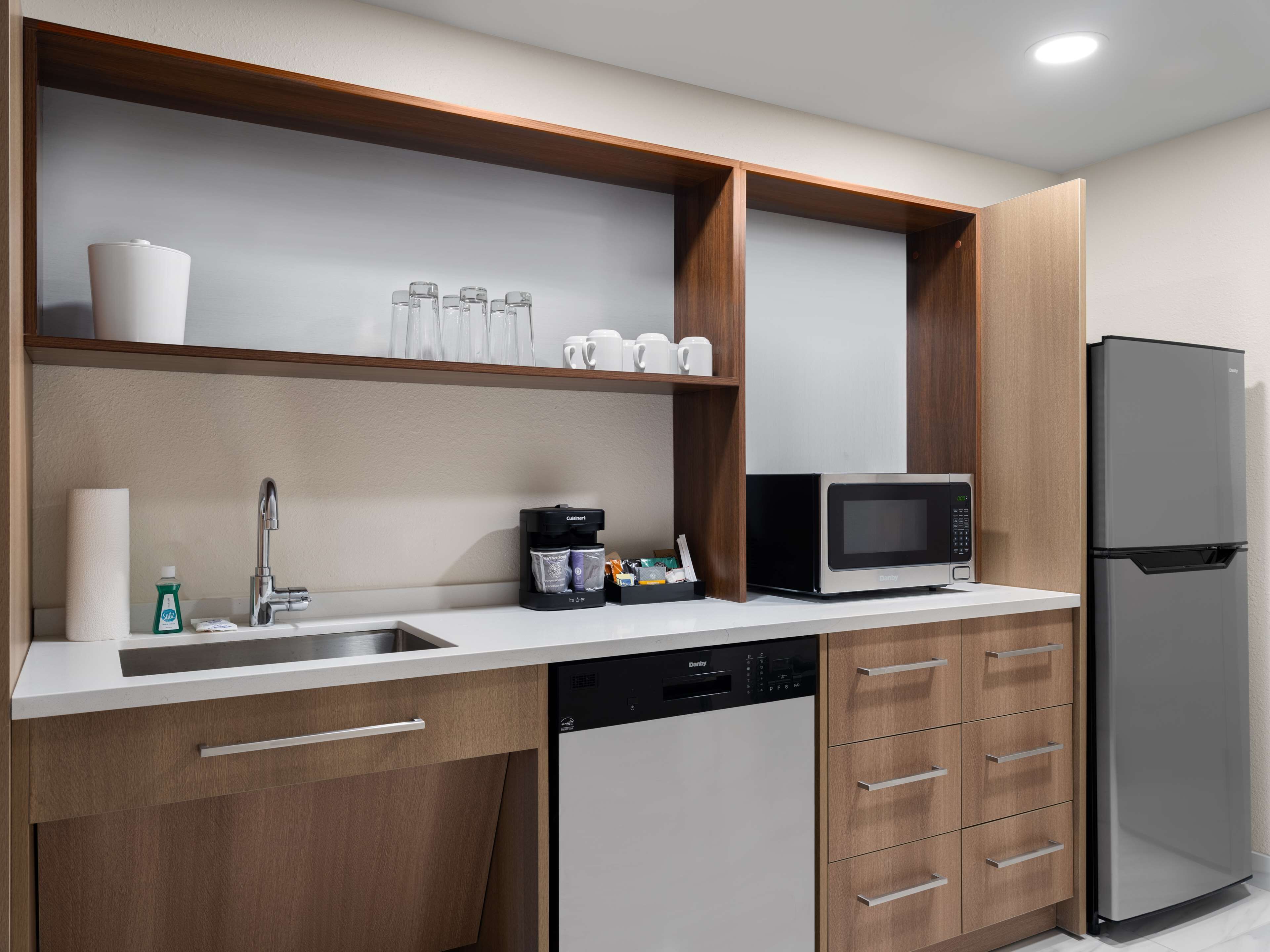 A modern kitchen with a built-in dishwasher, a microwave, and a refrigerator.