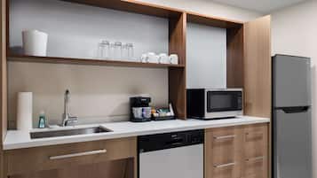 A modern kitchen with a built-in dishwasher, a microwave, and a refrigerator.