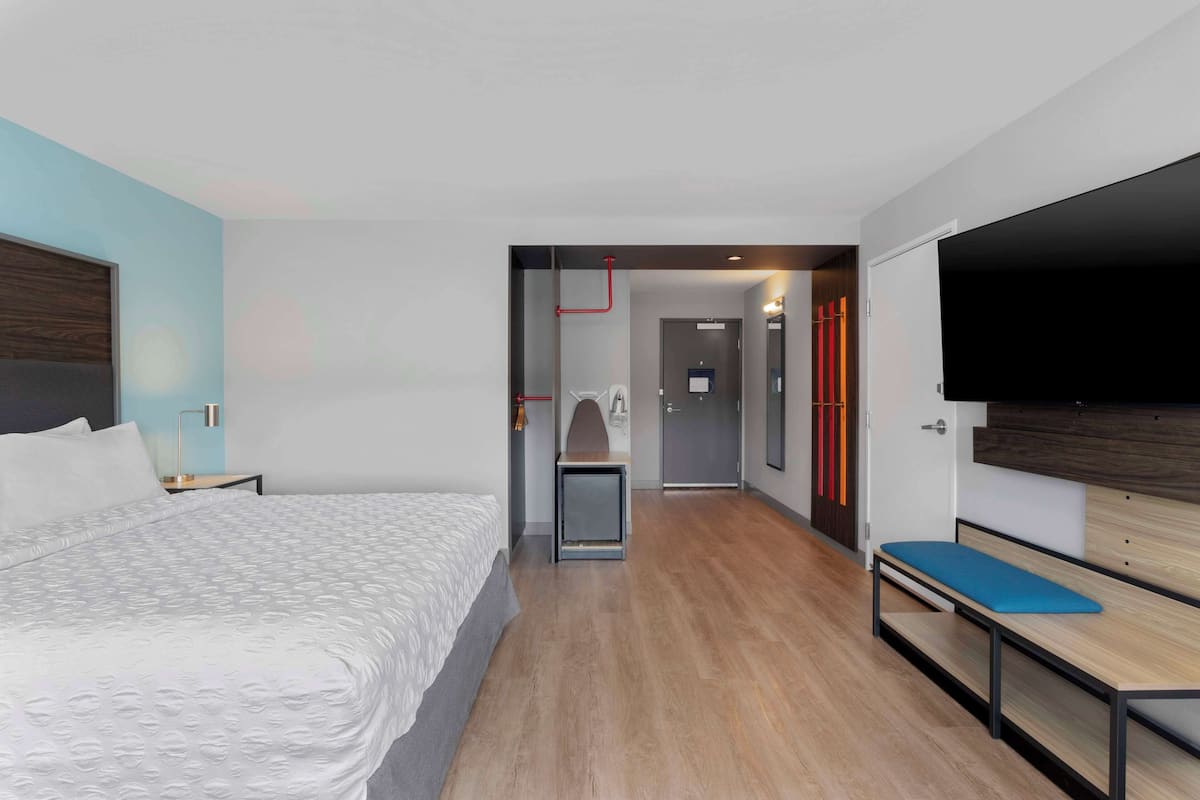 Habitació d'hotel moderna amb un llit gran, escriptori, una panxa i un televisor de pantalla plana.
