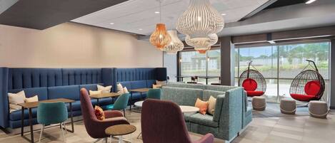 Un espace de détente moderne, aménagé avec différents types de sièges, notamment des canapés et des fauteuils, ainsi que des fauteuils suspendus.