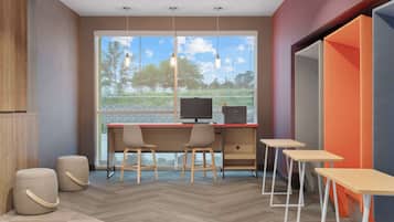A modern office space with a large window, two desks, two chairs, and a small table.