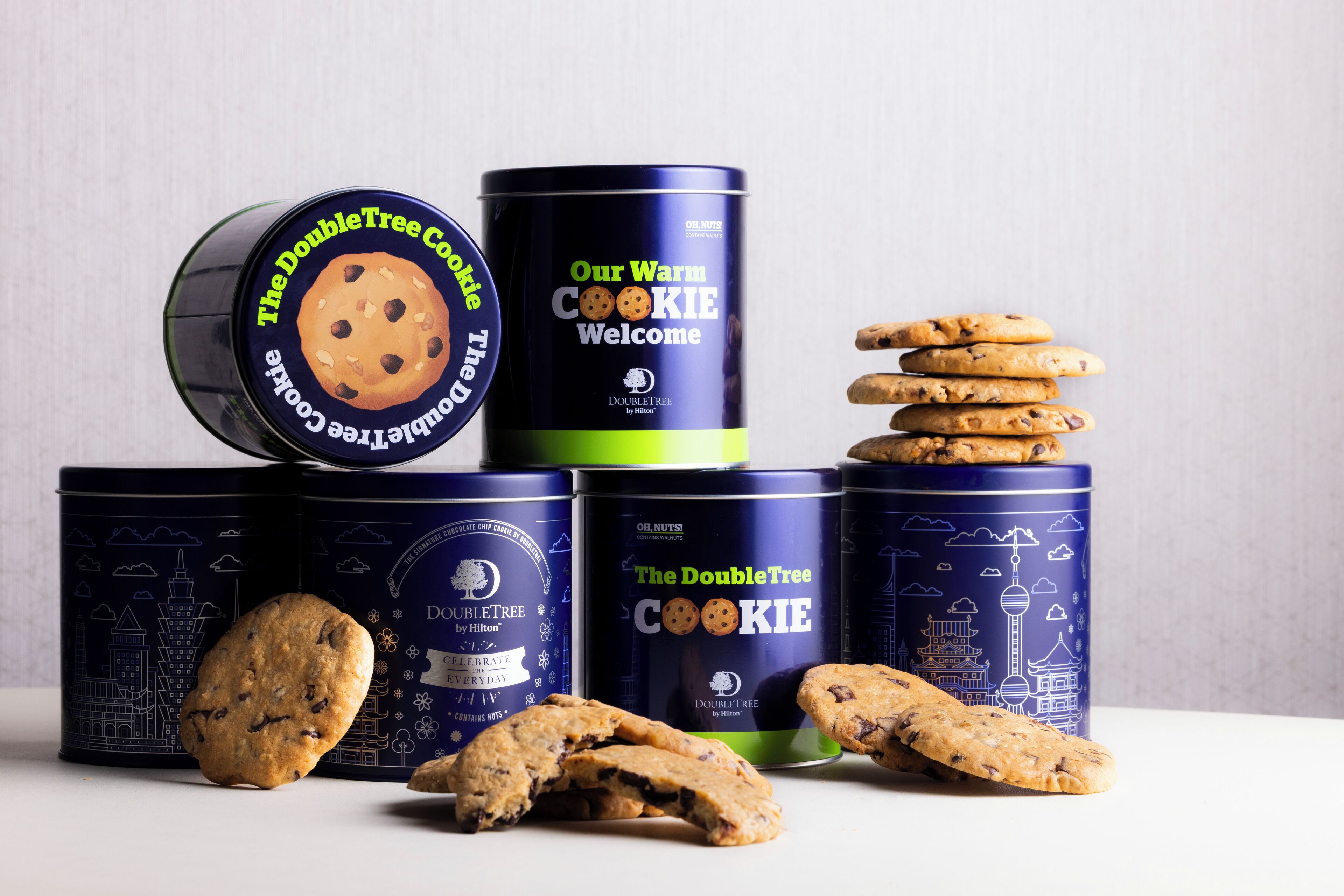 Kolme DoubleTree-keksejä sisältävää pakkausta, joiden kuvituksessa on kaupunkimaisema, yksi keksi ja yksi rikkinäinen keksi.