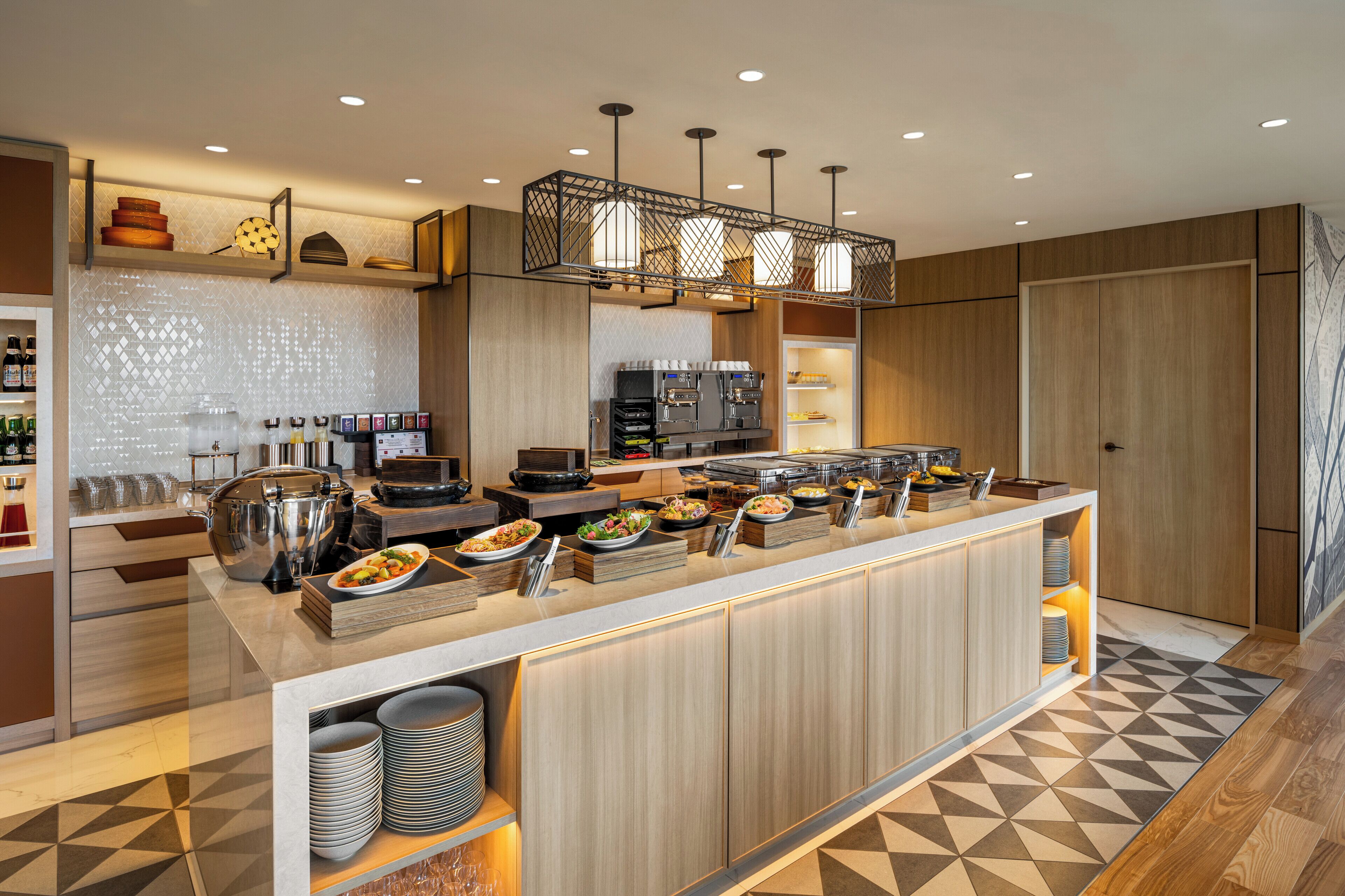 Una cocina moderna con una disposición tipo bufé, que incluye diferentes estaciones de comida y una máquina de café.