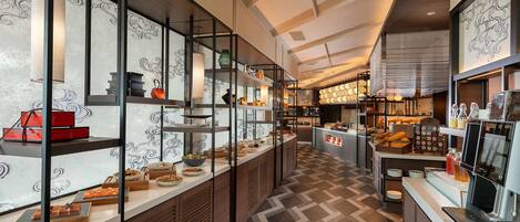 A modern kitchen with a central island, built-in shelves, and a patterned floor.
