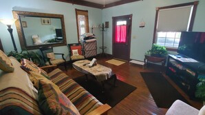 A living room with a sofa, a coffee table, a TV, and a mirror. - Big Beautiful House Close to Downtown Indianapolis with outdoor firepit  (Indianapolis)