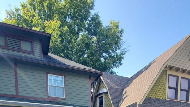A two-story house with a front porch, a covered entryway, and a small front yard with a pathway. - Big Beautiful House Close to Downtown Indianapolis with outdoor firepit  (Indianapolis)