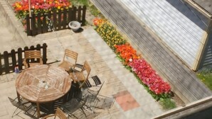 A patio with a round wooden table and chairs, a small fire pit, and a flower bed with colorful flowers. - Big Beautiful House Close to Downtown Indianapolis with outdoor firepit  (Indianapolis)