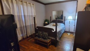 A bedroom with a bed, a bedside table, a lamp, a dresser, and a chair. - Big Beautiful House Close to Downtown Indianapolis with outdoor firepit  (Indianapolis)
