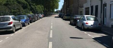 A street lined with parked cars and buildings.