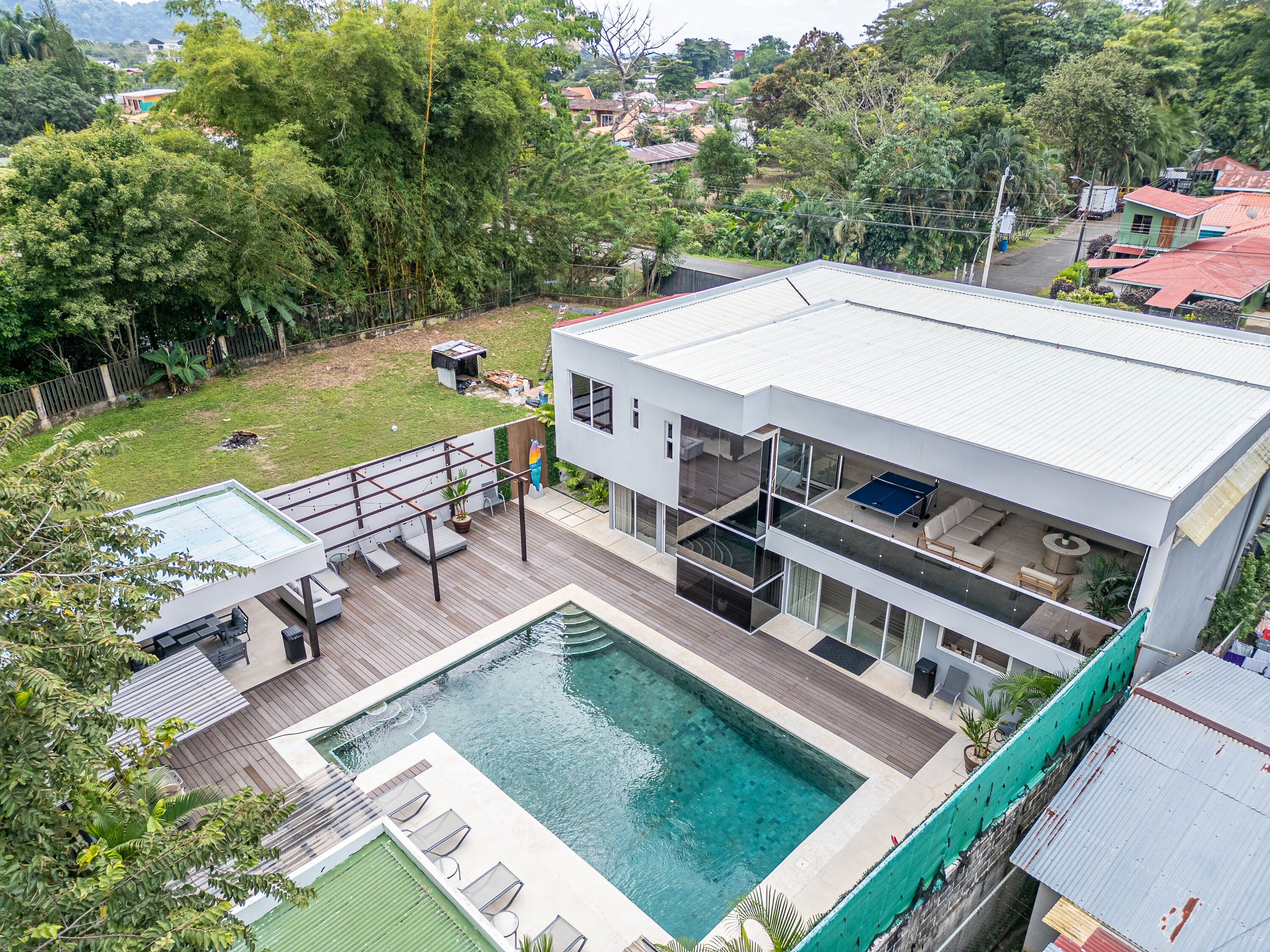 Ein modernes Haus mit Swimmingpool, Terrasse und einer Sitzterrasse.