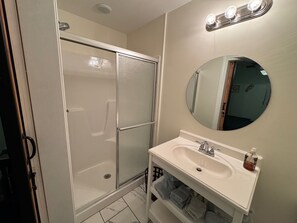 A bathroom with a shower, a sink, a mirror, and a towel rack. - Sweet Victory Bed and Breakfast (Stanford)