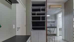 A kitchen with white cabinets, a black countertop, and a built-in shelving unit. - Av0909 in S o Paulo (São Paulo)