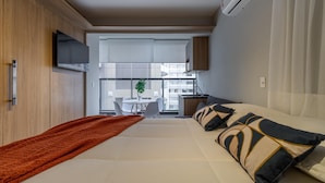 A modern hotel room with a bed, a TV, a desk, and a view of the city. - Wbe710 in S o Paulo (São Paulo)