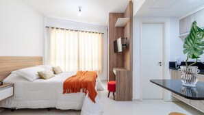 A modern bedroom with a bed, bedside table, and a small kitchenette area. - Av0905 in S o Paulo (São Paulo)