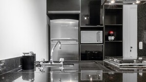 A modern kitchen with a stainless steel refrigerator, a coffee machine, and a sink with a faucet. - Haddock 166 in S o Paulo (São Paulo)