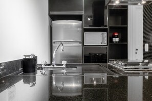 A modern kitchen with a stainless steel refrigerator, a coffee machine, and a sink with a faucet. - Haddock 166 in S o Paulo (São Paulo)