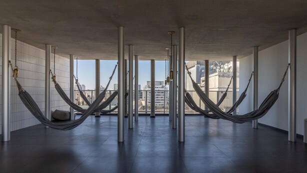 A spacious room with large windows, concrete pillars, and hammocks. - Freicaneca 111 in S o Paulo (São Paulo)