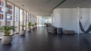 A spacious lobby with large potted plants, a seating area, and a hammock. - Freicaneca 111 in S o Paulo (São Paulo)